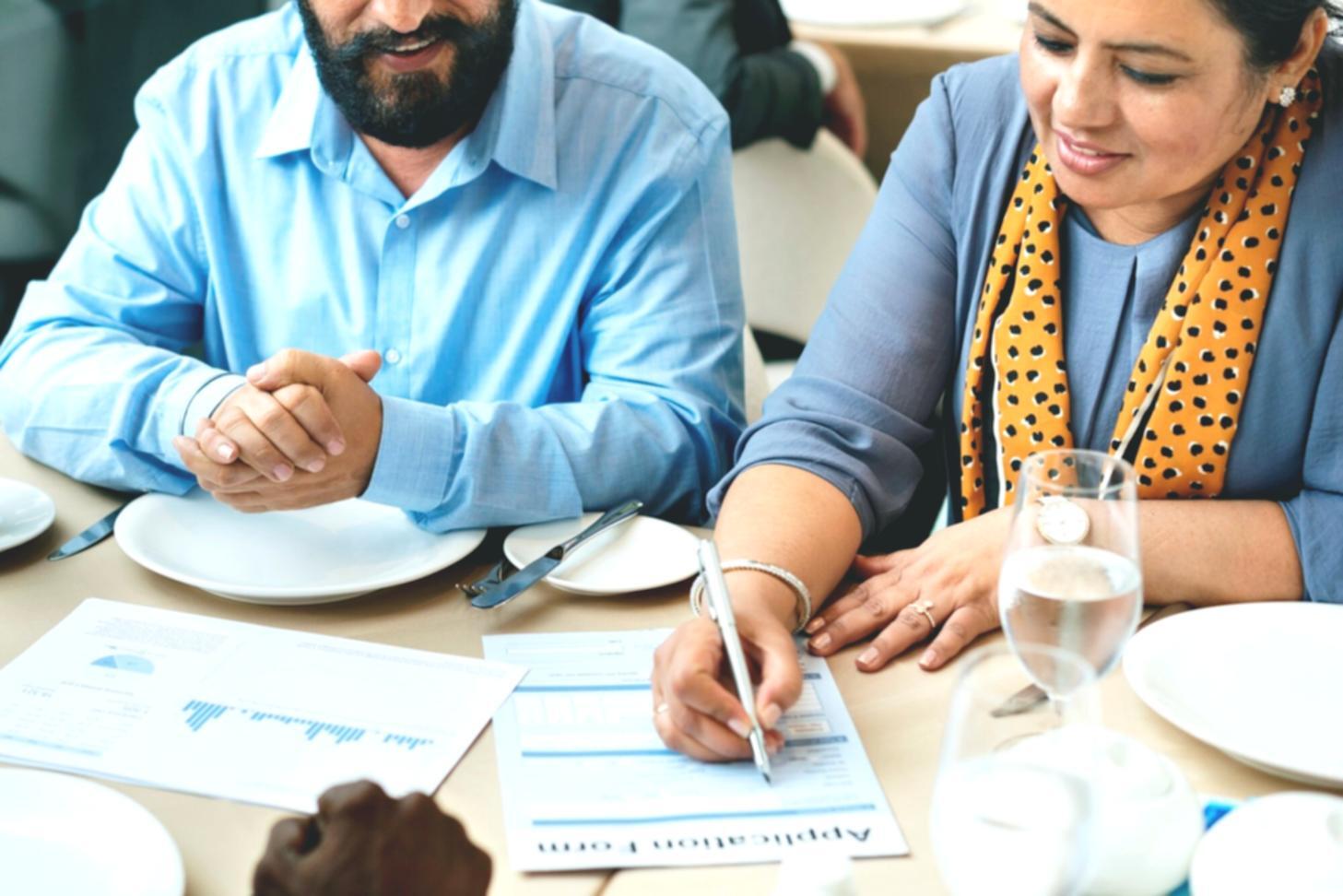 Geschäftsleute analysieren Finanzberichte und Markttrends in modernem Büroumfeld